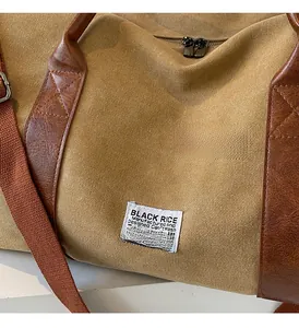 Close-up of khaki canvas travel bag showing faux leather handles and fine stitching