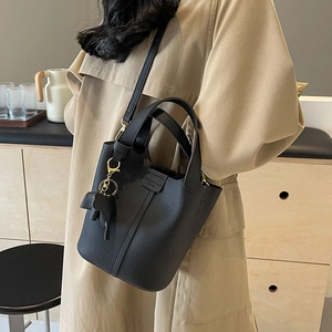 Women's black lychee leather bucket bag with top handles and cute cat charm accessory