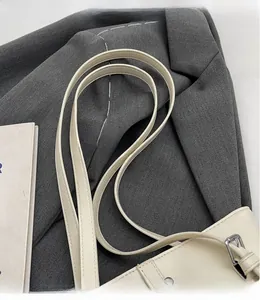 Détail du sac à bandoulière blanc crème avec fines doubles sangles et boucles métalliques