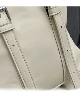 Détail du sac cabas ivoire montrant le similicuir texturé et la boucle argentée réglable