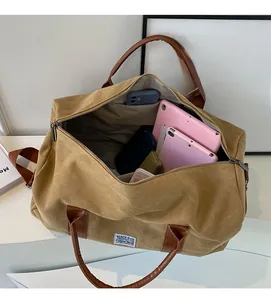 Top view of large khaki canvas travel bag showing spacious interior and leather handles