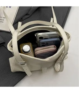Vue de dessus montrant l'intérieur spacieux d'un sac cabas crème avec portefeuille