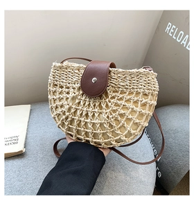 Detail of hand-woven straw tote with brown leather flap and silver magnetic clasp closure