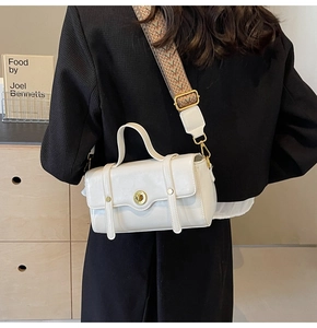 Detail of white leather crossbody bag with geometric wave pattern wide strap and gold lock