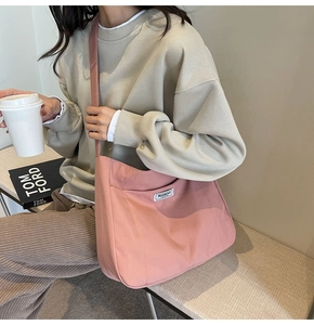 Close-up of pink canvas tote bag showing durable texture and white brand logo patch