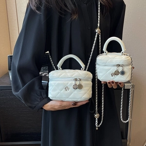 Weiße gesteppte Mini-Eimertasche mit Silberkette in zwei Größen von Model gezeigt