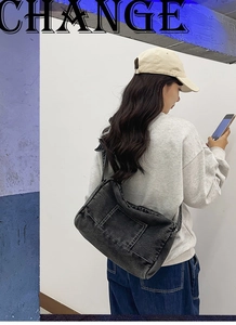Détail du sac cabas en jean noir avec poche avant pratique et bandoulière réglable