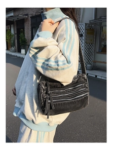Detail of black washed denim tote bag with functional multi-layer zippers for women