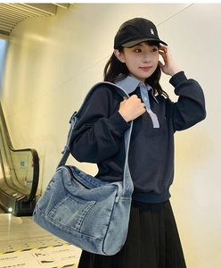 Détail du grand sac cabas en jean bleu avec bandoulière large et poche latérale pratique