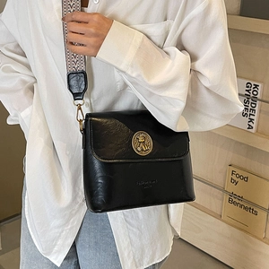 Sac seau en cuir noir avec emblème doré rétro et large bandoulière à motifs