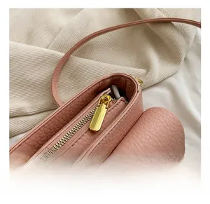 Macro detail of high-quality gold zipper and pink pebble leather texture on small bag