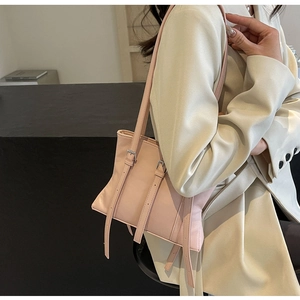 Détail du sac cabas rose clair montrant la texture cuir mat lisse et les boucles argentées