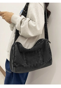 Détail d'un sac cabas en denim anthracite avec bandoulière cloutée à motif léopard chic