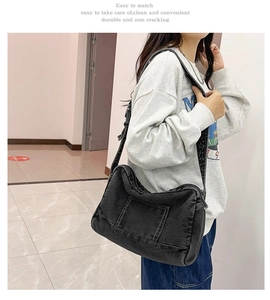 Détail du sac cabas en denim noir avec poche à coutures et large bandoulière