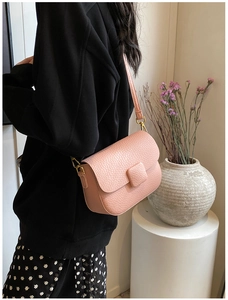 Close-up of pink litchi pattern texture and gold hardware on the crossbody flap bag