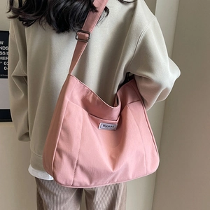 Pink canvas tote bag with adjustable shoulder strap and fashion label for daily commute