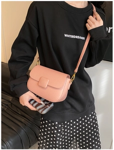 Pink crossbody bag with lychee texture, flap closure and gold metal buckles shown on model