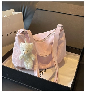Detailansicht einer rosa Falten-Tasche mit süßem Bärenanhänger in einer Geschenkbox