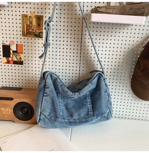 Détail de la boucle métallique réglable sur le sac en jean avec poche avant rétro