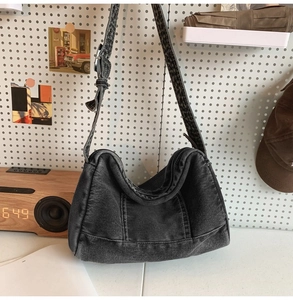 Détail du sac hobo en jean noir délavé vintage avec bandoulière large réglable et boucle en métal