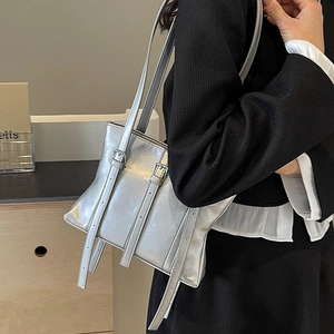 Sac fourre-tout argenté minimaliste avec finition métallique et boucles sur un modèle
