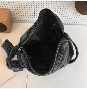 Détail de l'intérieur d'un sac en jean avec compartiment spacieux et poche zippée