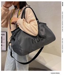 Detail of grey waterproof sports bag with NOCO branding and detachable shoulder strap
