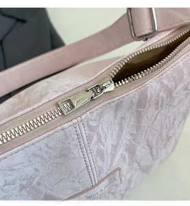Detail eines glatten Silber-Reißverschlusses und gerafftem rosa Kunstleder am Shopper