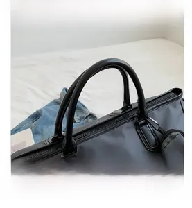 Detail of waterproof travel bag with leather handles and detachable small round pouch