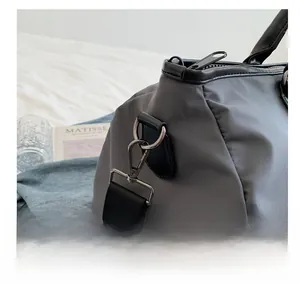 Detail of durable black metal hook and strap on waterproof dark grey travel bag