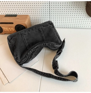 Détail du sac bandoulière en denim noir délavé avec sangle réglable et texture rétro