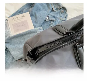 Detail view of smooth resin zipper and durable nylon fabric on a gray travel sports bag