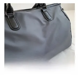 Detail shot of grey water-resistant nylon fabric and large NOCO logo on a sports gym bag