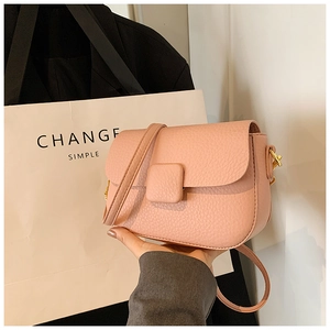 Close-up of pink litchi grain crossbody bag with gold hardware and flap closure
