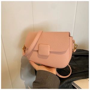 Close-up of pink lychee grain leather crossbody bag with elegant gold hardware