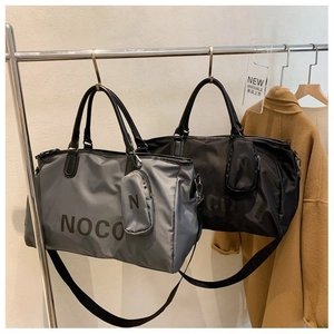 Close-up of large travel duffle bags in grey and black with detachable small pouch