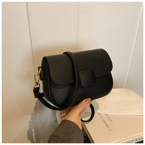 Detailed close-up of the black lychee pattern leather flap and golden metal hardware