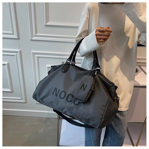 Detail of dark grey travel bag with NOCU logo and matching small attachment pouch