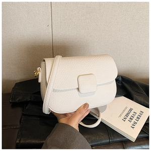 Close-up of cream white crossbody bag in lychee pattern leather with square magnetic buckle