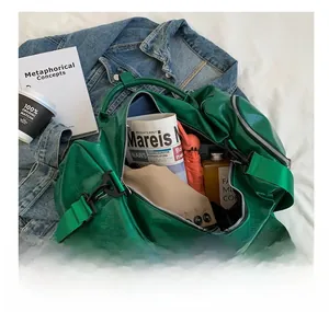 Detail showing high-capacity interior of green glossy travel bag with metal zippers