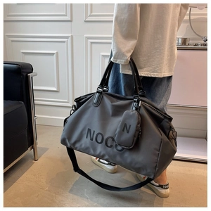 Detail of grey travel duffel bag with leather handles and a small matching pouch