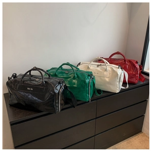 Boston style travel bags in black, green, cream, and red with glossy leather finish