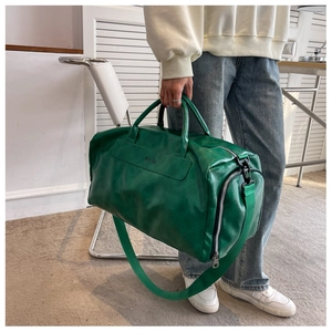 Detail of vintage green wet-dry travel bag with polished textured finish and Noco Bag logo