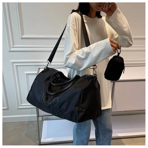 Detail of black large travel bag with detachable strap and matching mini pouch