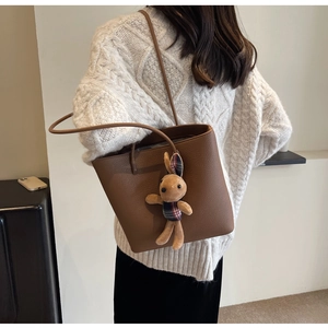 Brown lychee leather tote bag featuring a cute bunny charm and slender shoulder straps