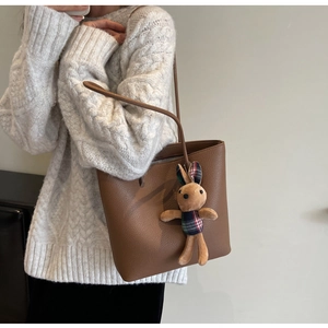 Brown faux leather tote bag with cute rabbit pendant shown on model for daily commute