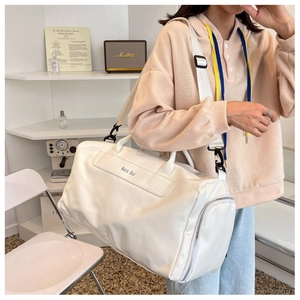 Detail view of large cream travel bag with adjustable strap and Noco Bag branding