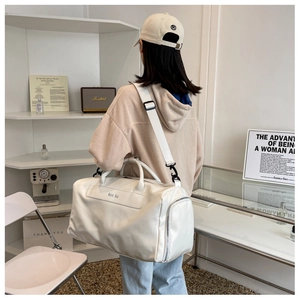 Detail view of large white PU leather travel bag with adjustable strap and side pocket