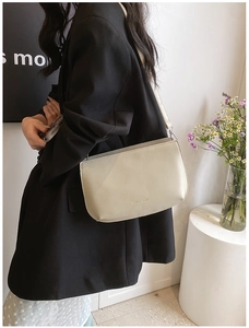 Détail du sac à bandoulière en similicuir beige crème avec logo de marque gaufré