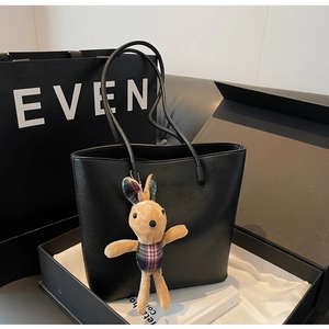 Detail of black pebbled leather tote bag with bunny charm in a premium gift box